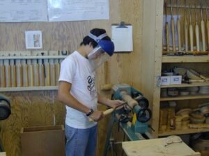 Student roughing out spindle for candlestick