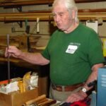Holding a long rectangular oil-hardening steel bar and some of the many tools he has made