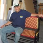 Rob sitting on his bench made from turned spindles and woven maple stripps